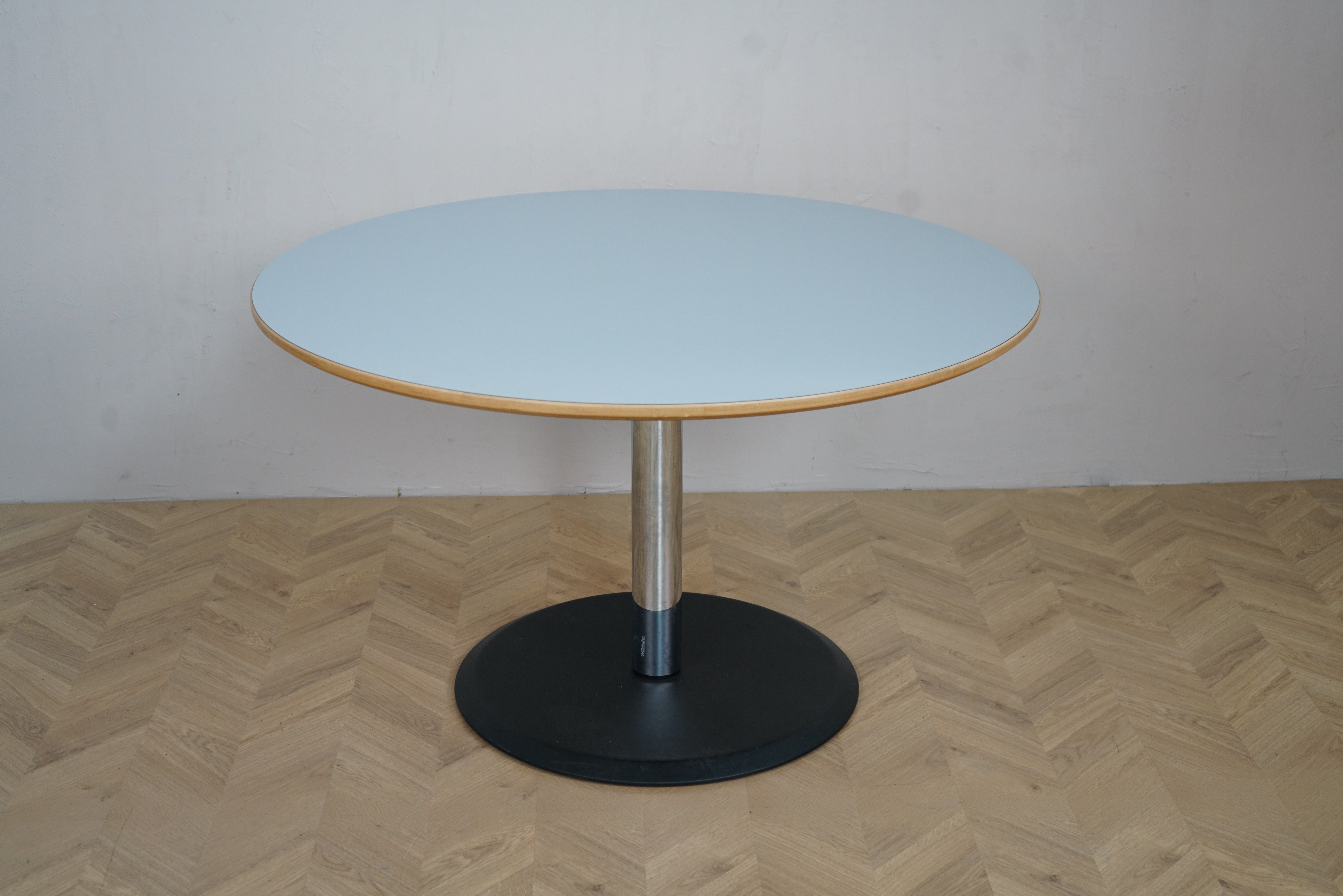 Rundt bord Ø124 cm med lyseblå laminatplade og sort søjle stel set forfra – ideelt som cafébord, mødebord eller spisebord